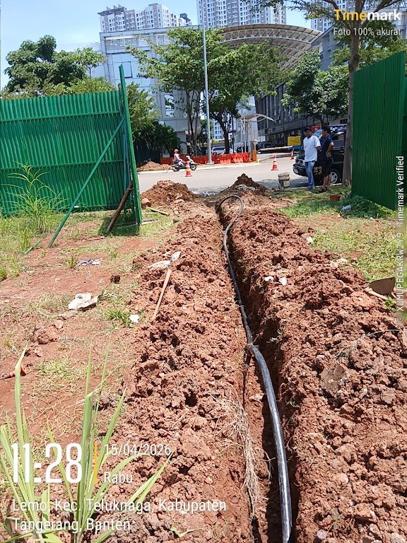 Pekerja meregangkan dan memastikan bentangan kabel selubung hitam kuat pada jalur open cut