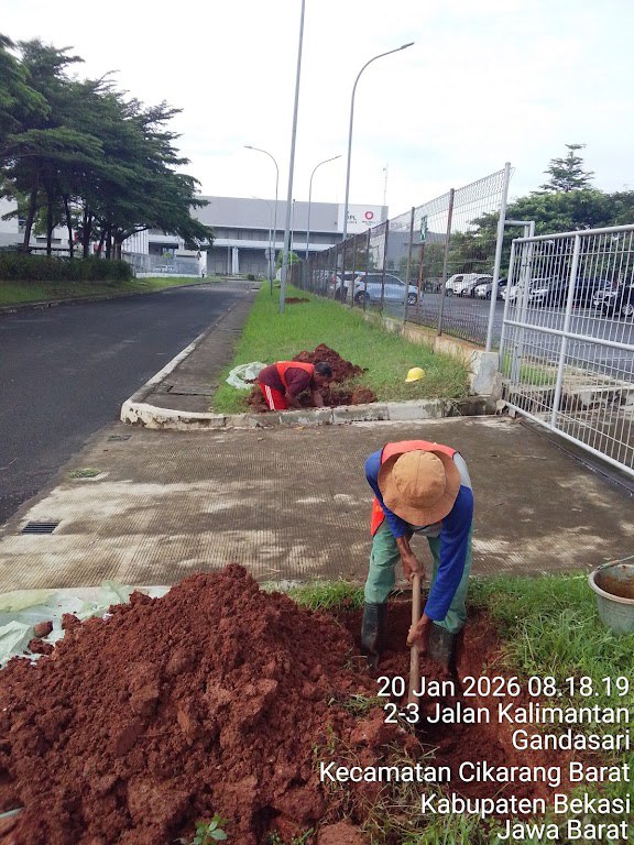 Dua pekerja menggali lubang pit di kanan-kiri jalan gerbang untuk persiapan boring horizontal