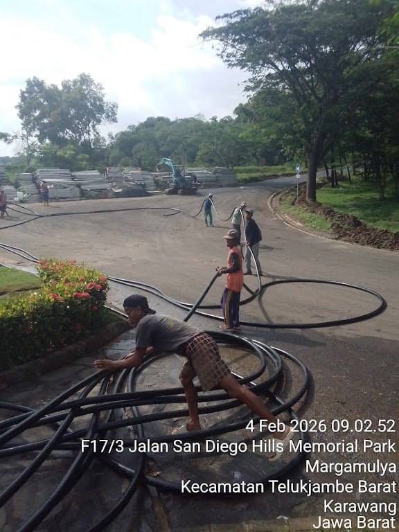 Teknisi melakukan penyambungan kabel di dalam jalur galian